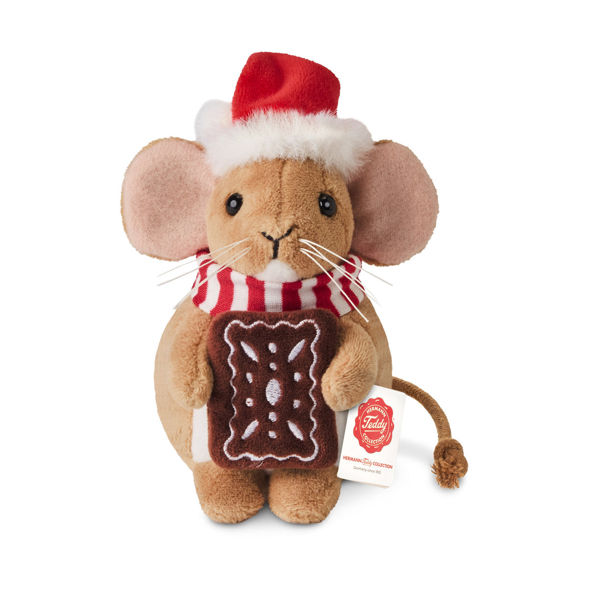 Det här är en julmus från Teddy-Hermann. Kort, tät och mjukt skimrande brun päls, vit magfläck och vit haka. Öronens insida är ljusrosa, tassarna bruna med trampdynor i samma färg. Ögonen är svarta och runda, nosen svart och broderad i triangelform, med vita morrhår på var sida. Musen sitter upprätt, håller en rektangulär pepparkaka och bär en röd tomteluva med vit kant och en rödvitrandig stickad halsduk. Uttrycket verkar lugnt och nöjt.