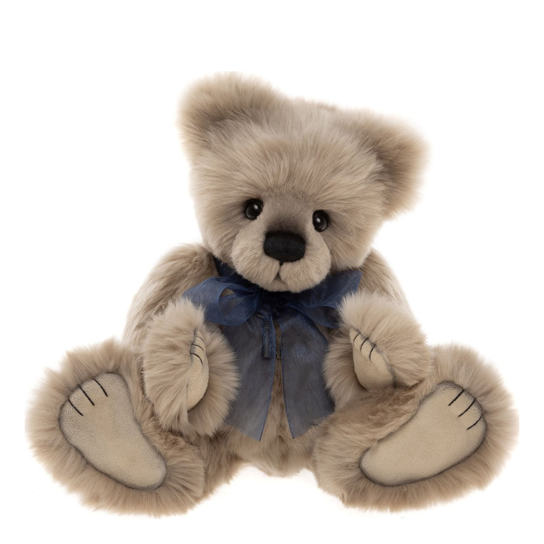 Det här är Howarth, en nalle från Charlie Bears. Han sitter och har lång, tät och lätt silkig päls i beige med en svag grå ton i skuggorna och mjuk glans. Nospartiet är något mörkare gråbeige, medan öronens insida, magen och tassarna är beige med släta trampdynor. Ögonen är runda och svarta, nosen svart och oval med ett sytt svart munstreck. Inga ränder eller fläckar. Han bär en genomskinlig marinblå rosett kring halsen och ett nyckelhalsband i antikguld. Minen är lugn och mild.