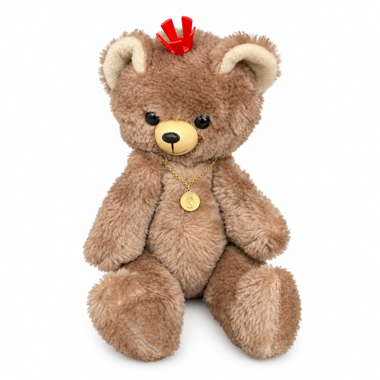 Det här är DDR Berlin-nallen, en nalle från en japansk tillverkare. Den är ledad, sitter upprätt och kan inte stå. Pälsen är brun, medellång och lite lurvig med mjuk glans. Öronens insida, nosen och magen är beige och kortare och tätare än den övriga pälsen. Ögonen är svarta och runda, nostrynet ljusgult och ovalt med ett svart lodrätt streck. På huvudet sitter en röd plastkrona och runt halsen ett guldfärgat medaljonghalsband, medan blomman som ska sitta i handen saknas. Minen är mild och neutral.