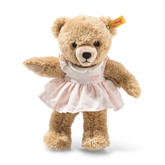 Det här är Sleep Well Bear, en nalle från Steiff. Mellanstor nalle med lång, lite rufsig beige päls med mjuka lockar och svag glans. Nospartiet och trampdynorna är ljusare vita och bryter av mot pälsen, öronens insida är beige. Ögonen är svarta och runda, nosen svart och rundad med broderad svart mun under. Inga andra markeringar. Hon bär en avtagbar rosa klänning med vita prickar, litet broderat motiv på livet, veckad kjol och krage. Hon sitter och ser lugn och sömnig ut.