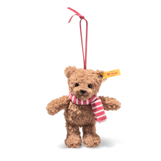 Det här är Ben, en nalle från Steiff. Han sitter upprätt och har mjuk, halvlång lockig päls med matt lyster. Pälsen är brun rakt igenom: nospartiet är brunt med en tydlig svart, triangelformad nos och en sydd svart mun, ögonen är runda och svarta, öronen bruna, magen brun, tassarna bruna och trampdynorna i samma bruna päls. Inga särskilda tecken syns. Halsduken är randig i omväxlande rosa och vitt med mjukt stickat utseende, och han hänger i en smal bandögla. Ansiktet ger ett vänligt, milt intryck.