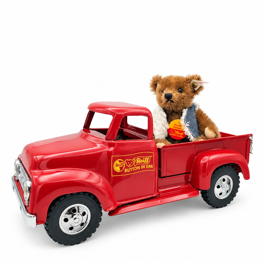 Det här är Specialleverans, en nalle från Steiff. Liten sittande nalle i mohair med kort till medellång, något rufsig päls med mjuk glans. Pälsen är brun med beige nosparti, beige insida på öronen, beige framsidor på tassarna och beige trampdynor; magen är lika brun som resten. Svarta runda ögon, svart triangulär nos. Han har en blå jeansväst med vit sherpakant och sitter på flaket i en röd pickup. Helt ledad, avslappnad sittställning och en vaken, vänlig min.